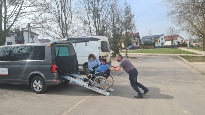 Brak nazwy  / Osoba niepełnosprawna wprowadzana na wózku do samochodu